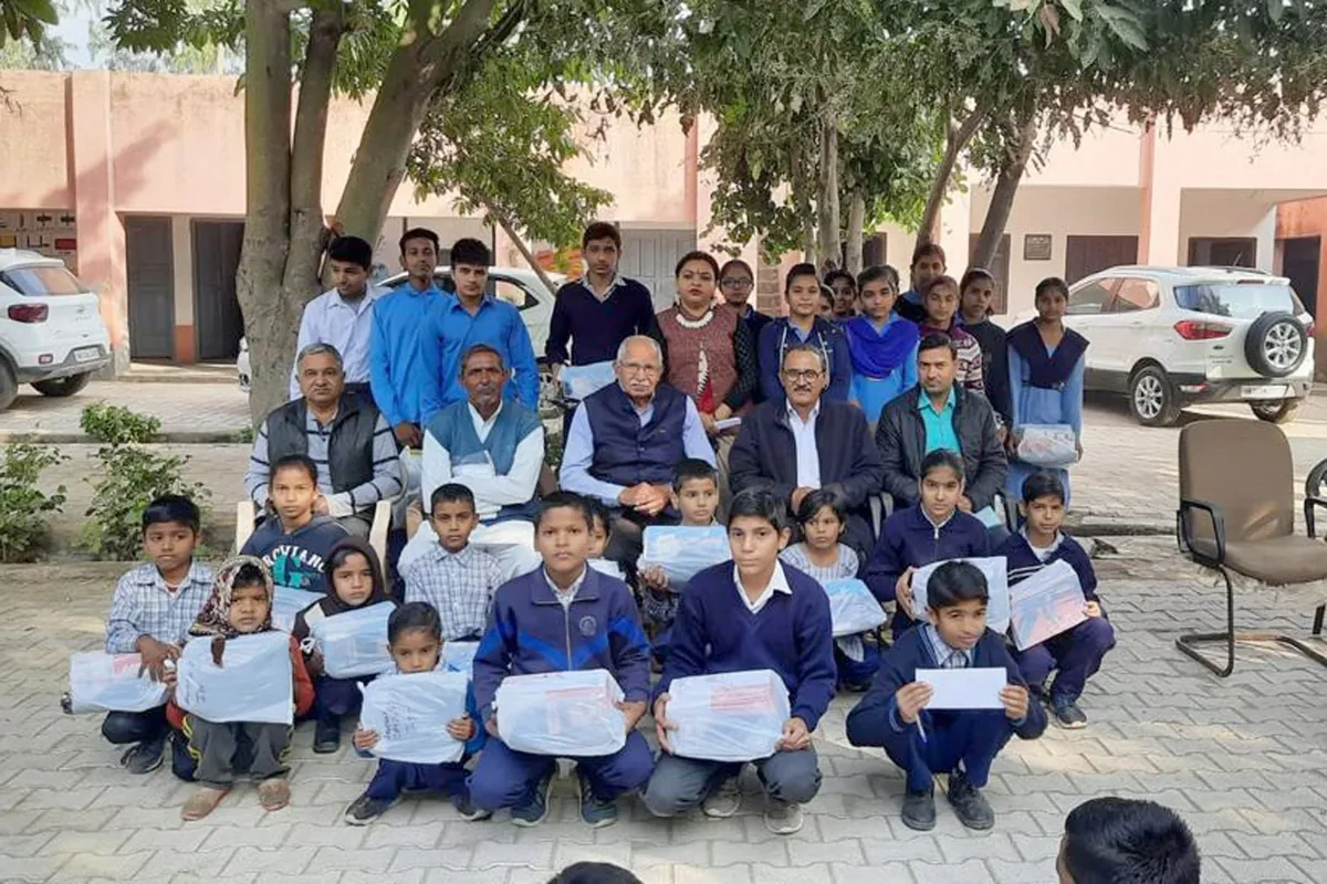 Schoolchildren and volunteers posing with winter clothes, 2021