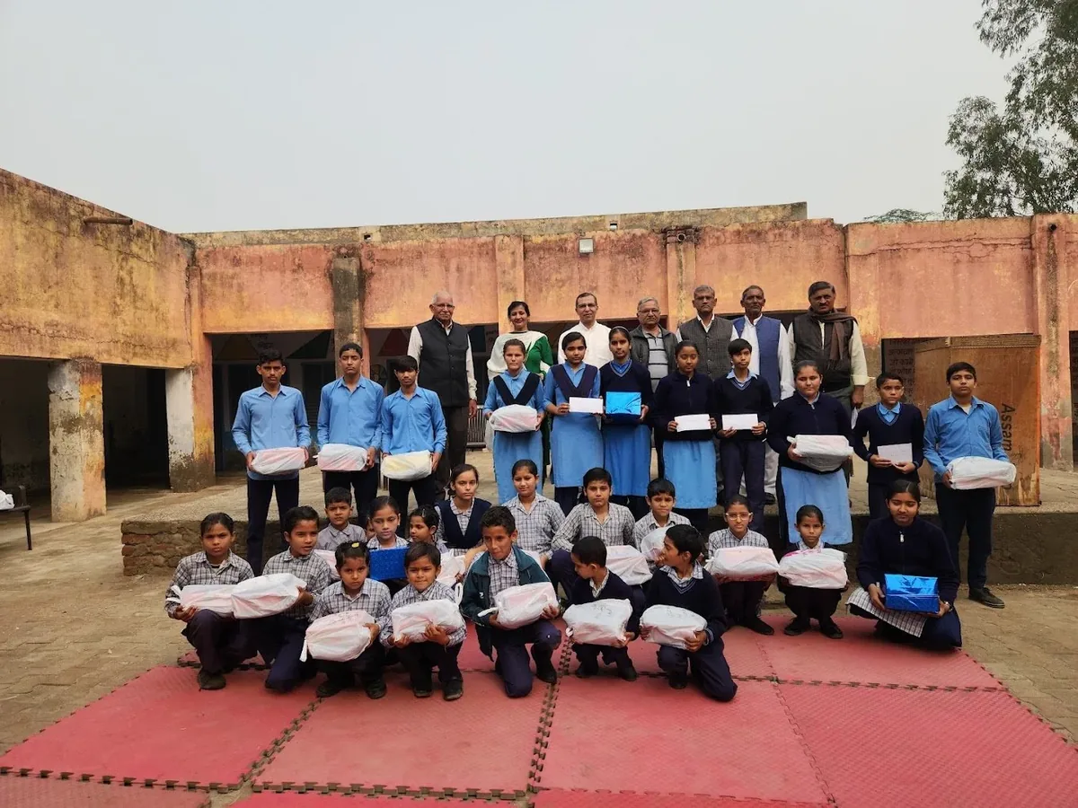 Schoolchildren and volunteers posing with winter clothes, 2023